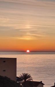 a sunset over the ocean with the sun in the horizon at MAX and SEA parking in Sanremo
