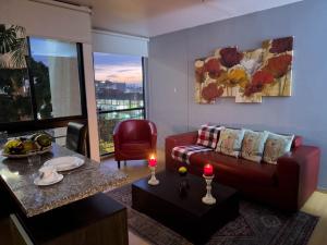 sala de estar con sofá y mesa con 2 velas en Modern Studio Apartment in Chapinero, Bogotá en Bogotá