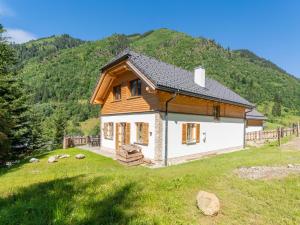 ein kleines Haus auf einem Feld mit einem Berg in der Unterkunft Bergzauber in Donnersbachwald