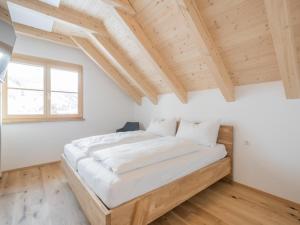 ein Schlafzimmer mit einem großen Bett in einem Zimmer mit Holzdecken in der Unterkunft Bergzauber in Donnersbachwald