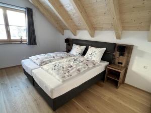 een slaapkamer met een groot bed en een houten plafond bij Haus Bente in Donnersbachwald