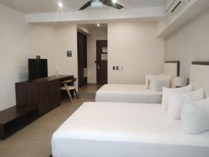 - une chambre avec 2 lits blancs et un bureau dans l'établissement Loft Hotel Malecón Vallarta, à Puerto Vallarta