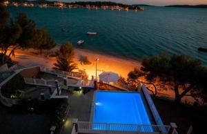 una vista di una spiaggia di notte con una piscina blu di Pinna Nobilis MoMa level 1 a Brodarica