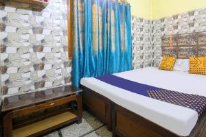 um quarto com uma cama e uma cortina azul em SPOT ON Hotel Sagar em Deoghar