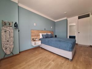 um quarto com uma cama azul e piso em madeira em Hotel Tierra del Sol Moquegua em Moquegua