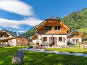 a log home in the mountains with a grass yard at Haus Laura in Donnersbachwald
