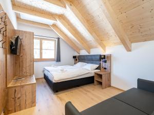 a bedroom with a bed in a room with wooden ceilings at Steier Hütte in Donnersbachwald