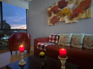 Sala de estar con sofá y mesa con 2 velas en Modern Studio Apartment in Chapinero, Bogotá en Bogotá