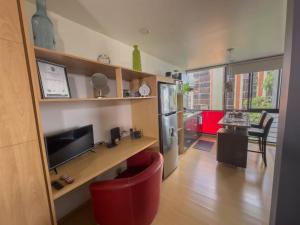 sala de estar con silla roja y TV en Modern Studio Apartment in Chapinero, Bogotá en Bogotá