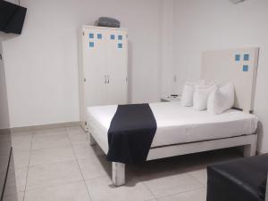 a bedroom with a white bed with a black blanket on it at Loft Hotel Malecón Vallarta in Puerto Vallarta