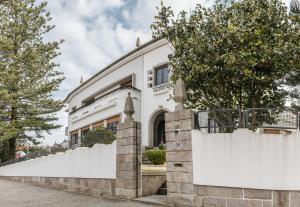une clôture blanche devant une maison dans l'établissement Espinho Vintage - Alojamento de Charme, à Espinho