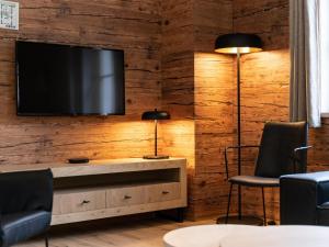 a living room with a television on a wooden wall at Villa Petra in Donnersbachwald