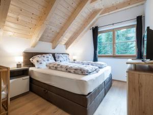 sypialnia z dużym łóżkiem i drewnianym sufitem w obiekcie Ebersberger w mieście Donnersbachwald