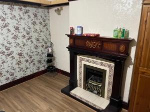 a fireplace in a living room with floral wallpaper at Leicester UK Fosse Park Shopping Centre Room 2 in Braunstone