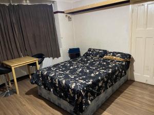 een slaapkamer met een bed, een tafel en een raam bij Leicester UK Fosse Park Shopping Centre Room 2 in Braunstone