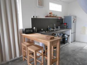 a kitchen with a wooden table and a refrigerator at Le Havre Gourmand in Rodrigues Island