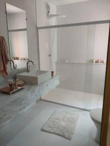 a white bathroom with a sink and a toilet at casadamaro in Santa Maria Madalena