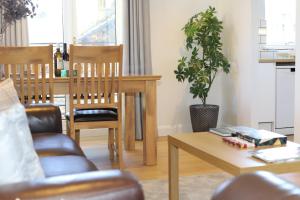 a living room with a table and a chair at Edinburgh Aparthotel in Edinburgh