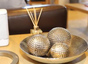 three silver balls in a bowl on a table at Edinburgh Aparthotel in Edinburgh