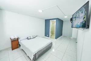 1 dormitorio con 1 cama y TV de pantalla plana en Casa Host 72, en Medellín