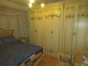 een slaapkamer met een bed en een kast bij Amazing Maadi Apartment ( Spa & fitness ) in Caïro