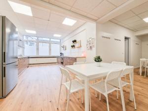 una cucina e una sala da pranzo con tavolo e sedie bianchi di RAJ Living - City Apartments with 5 Rooms - 10 Min Messe DUS a Dusseldorf