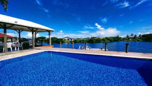 a swimming pool next to a body of water at Waterfront Sunset Apartment in Fantasy Island Nadi in Nadi