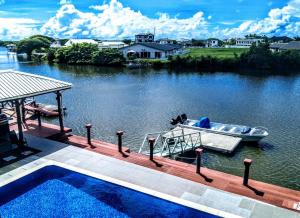 a boat on the water next to a dock at Waterfront Sunset Apartment in Fantasy Island Nadi in Nadi