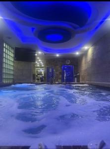 ein großer Pool mit Wasser in einem Zimmer mit blauen Lichtern in der Unterkunft Amazing Maadi Apartment ( Spa & fitness ) in Kairo