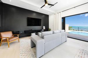 a living room with a white couch and a tv at Horizon West in Nassau