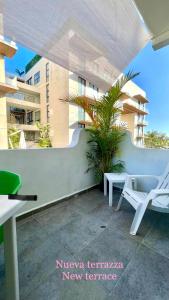 uma imagem de um pátio com uma cadeira e um edifício em Miranda Beach em Playa del Carmen