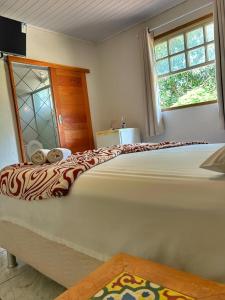 a large bed in a room with a window at Pousada Chafariz in Pirenópolis