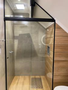 uma cabina de duche em vidro numa casa de banho com uma escada em Edelweiss Pomerode em Pomerode