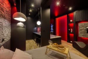a living room with red lighting and a bed and a table at Suite Deluxe - Jacuzzi in Melun +12 photos