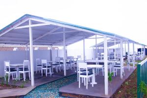 a group of tables and chairs under a pavilion at Hôtel Amazone in Cotonou
