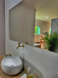 bagno con lavandino bianco e specchio di Pousada Chafariz a Pirenópolis