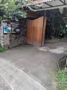 a wooden door in a driveway with a sign at Hotel campestre Villa Sarita in San Francisco