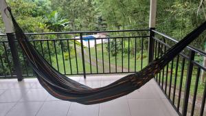 a hammock on a balcony with a view of a pool at Hotel campestre Villa Sarita in San Francisco