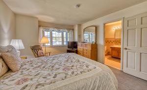 a bedroom with a bed and a desk and a mirror at Stunning Lake and Mountain Views, Pool, Beach, Walk to Town! in Lake Placid