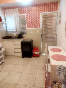 - une cuisine avec du papier peint rouge et blanc dans l'établissement Chalezinho em São Bernardo Campo com vaga, à São Bernardo do Campo