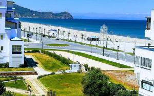 Blick auf den Strand, ein Gebäude und das Meer in der Unterkunft Wilaya Sunset Luxe, Private Jacuzzi & Hamam, Tetuan in Tétouan