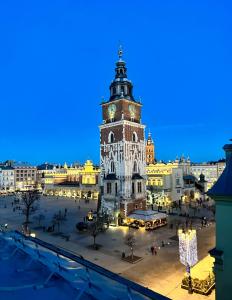 a view of a city with a clock tower at night at Apartament Luca in Krakow