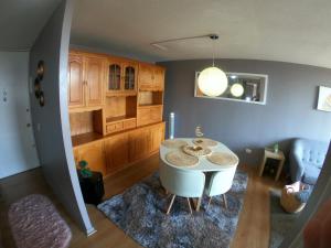 a living room with a white table and a kitchen at Departamento 2 Dormitorios Santiago in Santiago