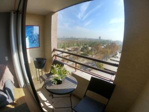 einen Balkon mit Stühlen, einem Tisch und Aussicht in der Unterkunft Departamento 2 Dormitorios Santiago in Santiago