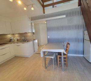uma cozinha com mesa e cadeiras num quarto em Beautiful T3 with balcony - near beach em Fréjus