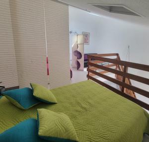 uma cama com lençóis e almofadas verdes num quarto em Beautiful T3 with balcony - near beach em Fréjus