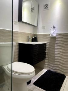 a bathroom with a toilet and a sink at Beachfront Bliss at Isla Verde in San Juan