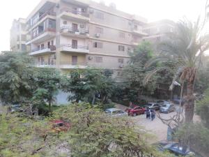een groot gebouw met auto's geparkeerd voor het bij Amazing Maadi Apartment ( Spa & fitness ) in Caïro
