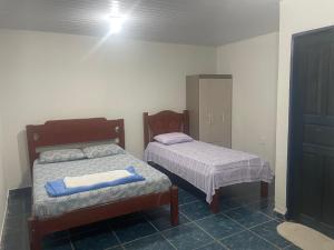 a bedroom with two beds and a cabinet at Canto da Liberdade in Boa Vista