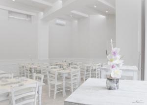 um quarto branco com mesas brancas e cadeiras brancas em Borgo albergo vulturis em Rapolla